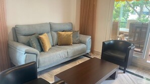 Un salon comprenant un canapé, deux fauteuils et une table basse.