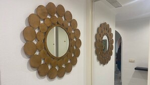 Un couloir orné de deux miroirs fixés aux murs, le tout encadré de décorations en bois de forme circulaire.