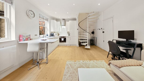 Een modern appartement met keuken, eethoek en woonkamer met televisie en zitplaatsen.