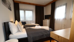 A modern hotel room with a bed, bedside table, and a TV. - Apartment Near the Kitzski Area (Jochberg)
