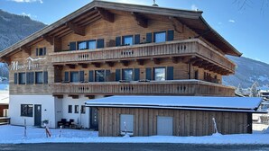 A wooden chalet with multiple balconies, a sign reading "Mount A Part," and a snowy landscape in the background. - Apartment Near the Kitzski Area (Jochberg)