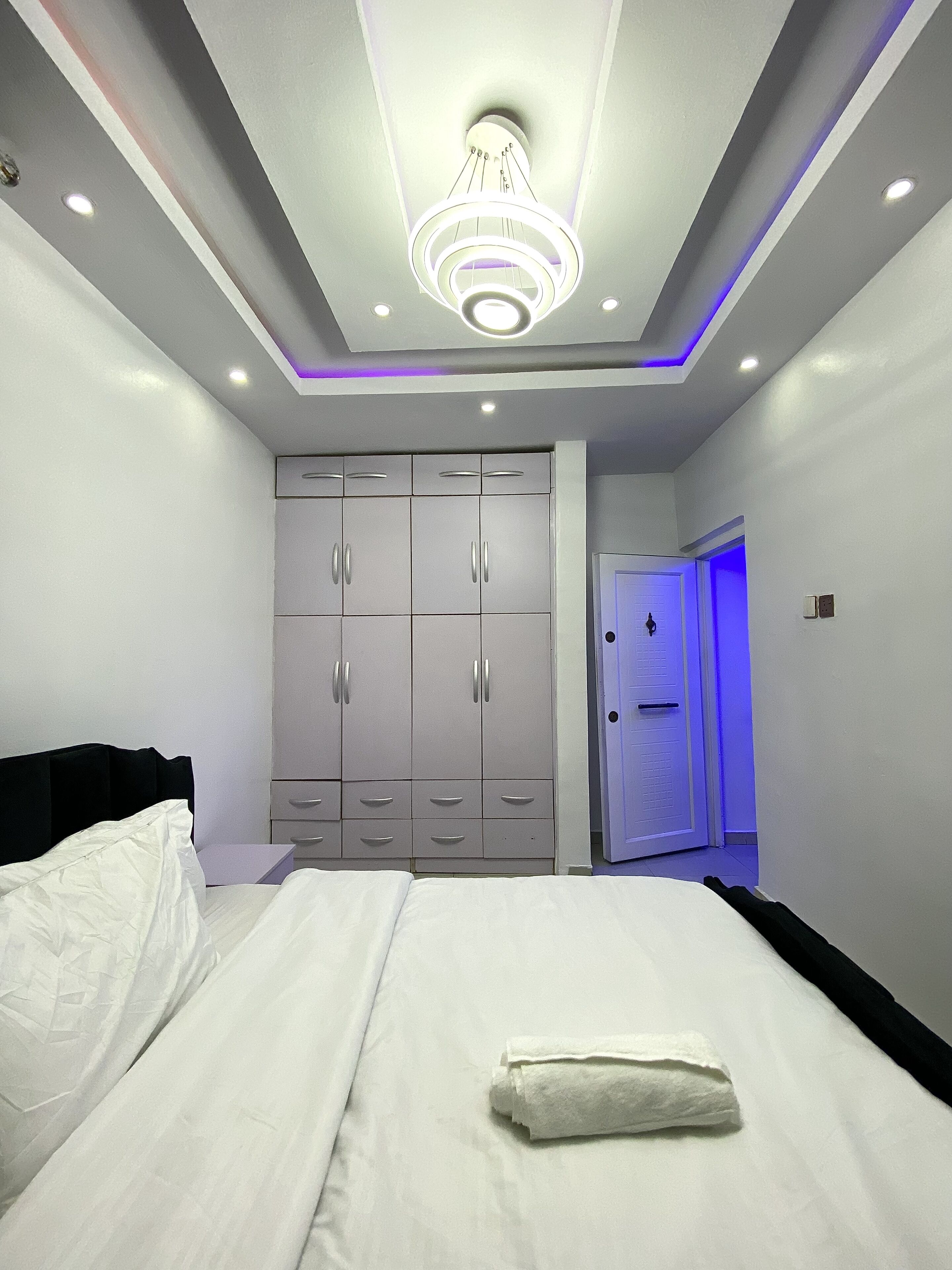 Un dormitorio moderno con cama, armario y puerta de baño.