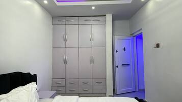 Un dormitorio moderno con cama, armario y puerta de baño.