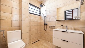 Ein modernes Badezimmer mit Dusche, Toilette und Waschtisch.