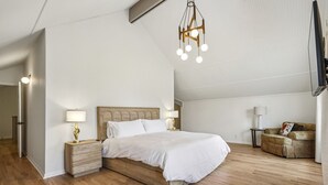 A bedroom with a wooden bed, bedside lamps, a hanging light fixture, and a sofa. - Game Room | Family House | Close to Buford Highway (Chamblee)