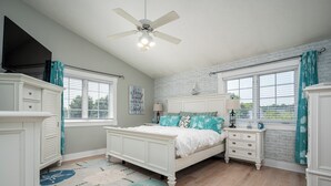 A bedroom with a bed, dresser, nightstand, and a ceiling fan. - Beautiful, spacious luxury home in Michigan for 12
. (Wyoming)