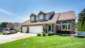 A two-story house with a garage, a driveway, and a well-maintained lawn. - Beautiful, spacious luxury home in Michigan for 12
. (Wyoming)