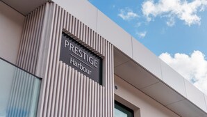 Um edifício com uma placa que diz "PRESTIGE Harbour".