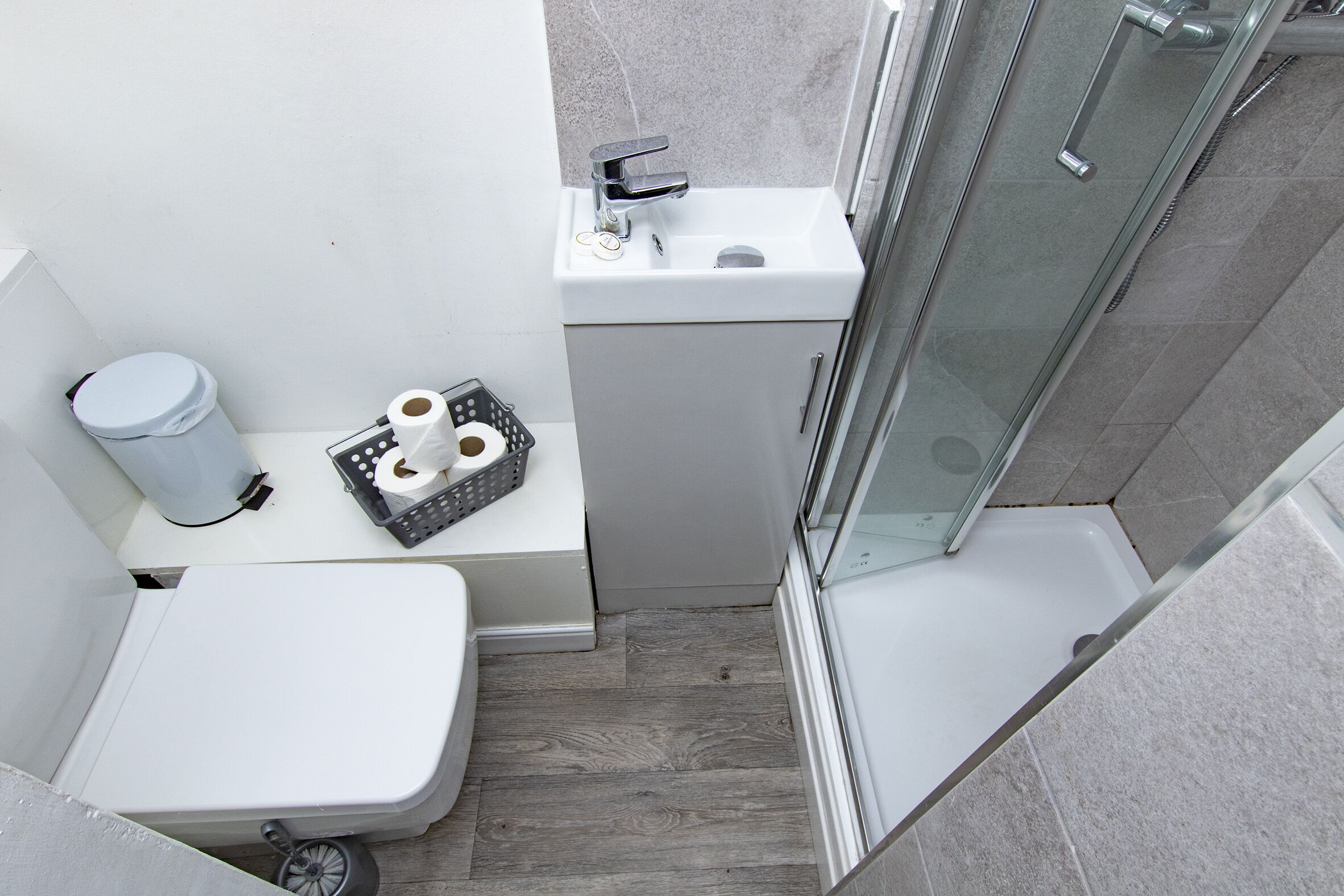 A compact bathroom with a toilet, sink, and shower.