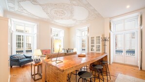 Una cocina amplia con una isla de madera, taburetes de bar y vistas al exterior a través de grandes ventanales.