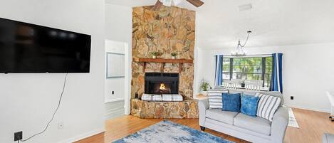 TV connectée, cheminée, table de tennis de table, livres