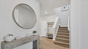 Ein modernes Interieur mit einer Holztruhe, einem großen Spiegel und einer Treppe.