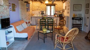 Un salon confortable avec un canapé, des fauteuils, une table basse et un téléviseur.