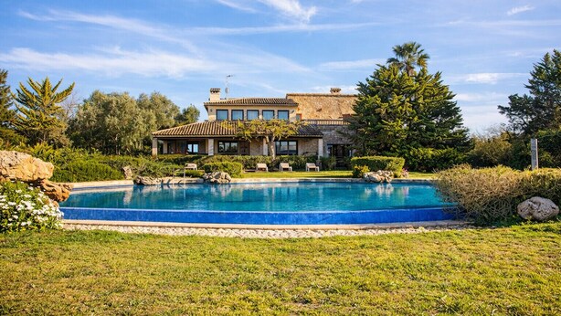 A large house with a swimming pool surrounded by a well-maintained lawn and trees. - Verd Salvatge by Rentallorca (Muro)