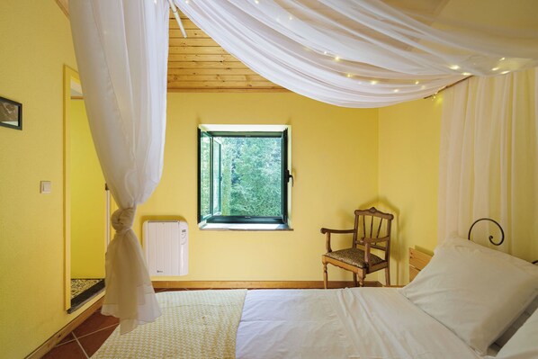 A bedroom with a bed, a chair, a window, and a curtain. - Be&See In River (Ovar)