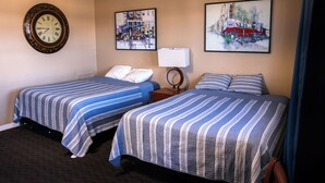 Ein Hotelzimmer mit zwei Betten, einer Uhr und zwei Bildern an der Wand.