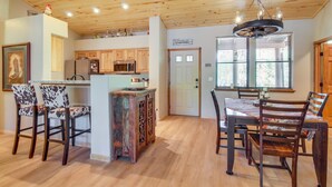 Un'ampia cucina con mobili in legno, un'area pranzo con un tavolo e sedie grandi, e un lampadario.