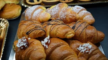 A variety of pastries including croissants and tarts on display.
