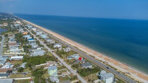 An aerial view of a coastal residential area with houses, a beach, and a road running parallel to the shore. - Flagler Beach Escape in the Sun (Flagler Beach)
