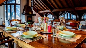 Een eettafel gedekt voor vier personen, met placemats, borden, bestek en glazen.