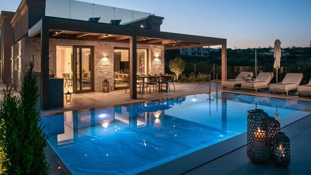 Uma casa moderna com piscina, área de estar externa e fachada de pedra.
