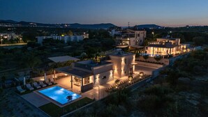 Uma villa moderna com piscina, vários quartos e um amplo espaço de pátio ao ar livre.