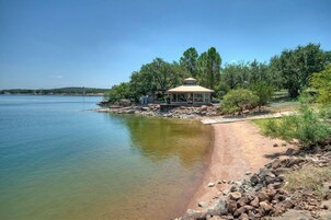 Un pabellón junto a un lago, con vista despejada del agua y los árboles circundantes.