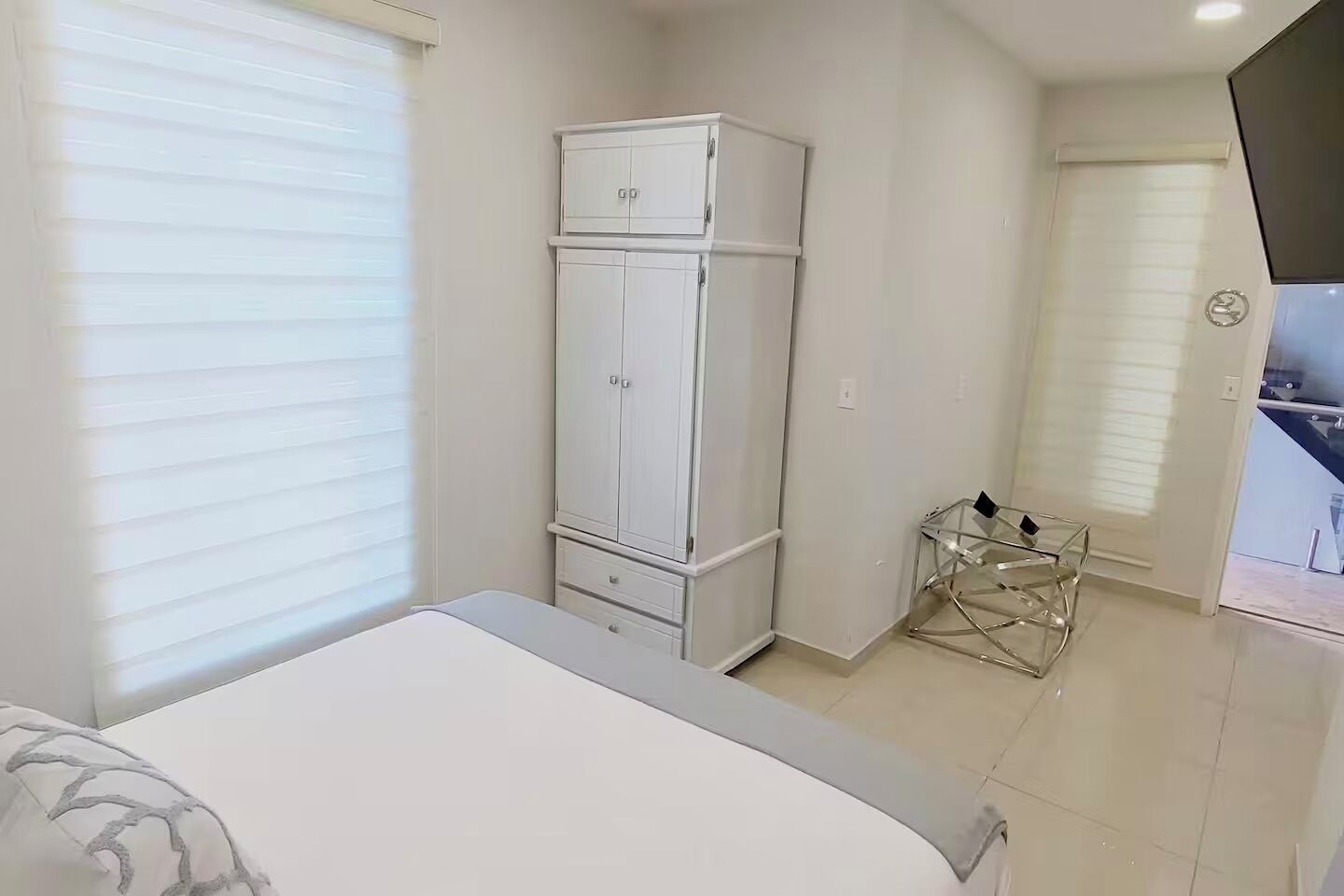 Une chambre à coucher avec un lit, une armoire et une petite table.