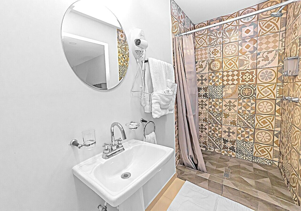 Een badkamer met een wastafel, spiegel en douche.