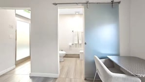 Une salle de bain moderne équipée de toilettes, d’un lavabo et d’une zone douche.