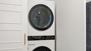 A laundry room with two stacked front-loading washing machines. - Cute, Cozy, and Curated South Hill Gem - 4 min to Manito Park (Spokane)
