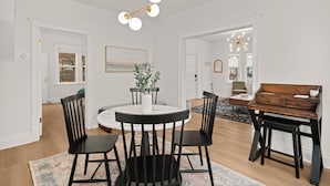 A dining area with a round table, black chairs, and a central vase. - Cute, Cozy, and Curated South Hill Gem - 4 min to Manito Park (Spokane)