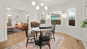 A dining area with a round table, black chairs, and a patterned rug. - Cute, Cozy, and Curated South Hill Gem - 4 min to Manito Park (Spokane)
