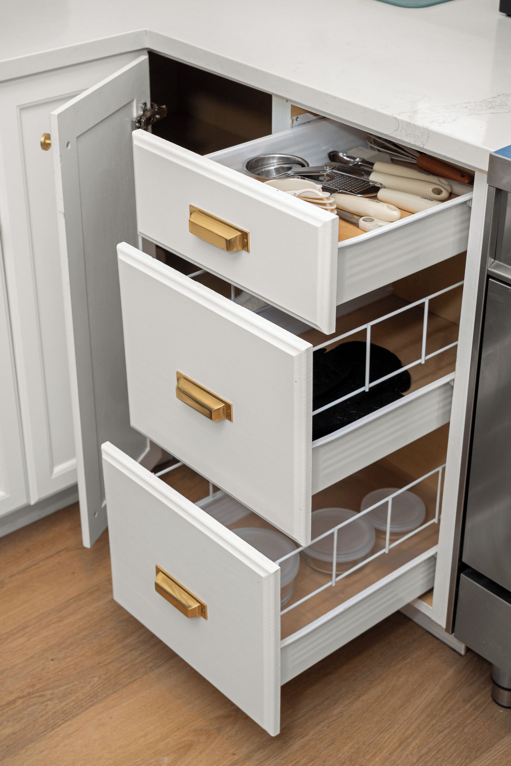 A kitchen with white cabinets, a stainless steel refrigerator, and a built-in oven.