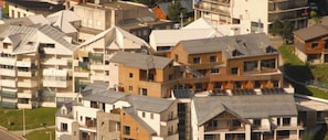 Un quartier résidentiel composé d’immeubles à plusieurs étages, dont certains sont dotés de balcons apparents et de panneaux solaires.