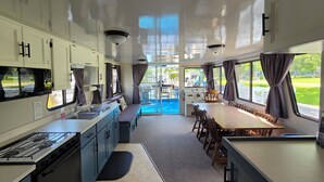 Une cuisine compacte équipée d’une cuisinière, d’un évier et d’un coin repas avec une table et des chaises.