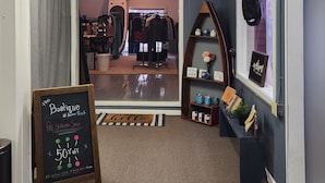 L’entrée d’une boutique, avec une enseigne indiquant « The Boatique at Anchor Point » et un panneau noir annonçant une vente de pré-saison.