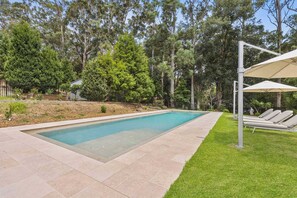 A rectangular swimming pool with a tiled edge, surrounded by a well-maintained lawn and trees. - Hamptons Estate: Freshwater Pool, 8 Mins Beach (Terrigal)