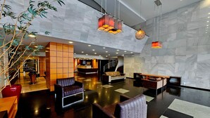 A spacious lobby with a reception desk, seating areas, and a staircase leading to upper floors. - Santoni Hotel Guarapuava (Guarapuava)