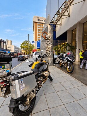 A motorcycle parked in front of a building with a sign that reads 'SANTON HOTEL'.
