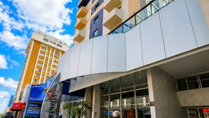 A modern hotel with a prominent entrance, large windows, and a clear sky. - Santoni Hotel Guarapuava (Guarapuava)