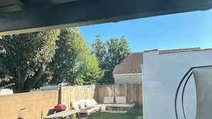 A backyard with a trampoline, a bicycle, and a picnic table.