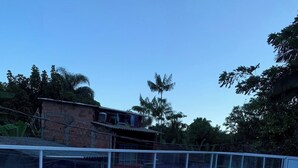 Et rummeligt udendørsareal med flisegulv, omgivet af et hvidt gelænder.