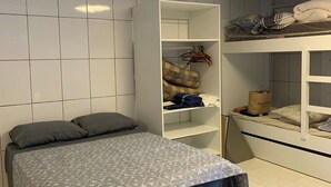 Et soveværelse med seng, garderobeskab og køjeseng.