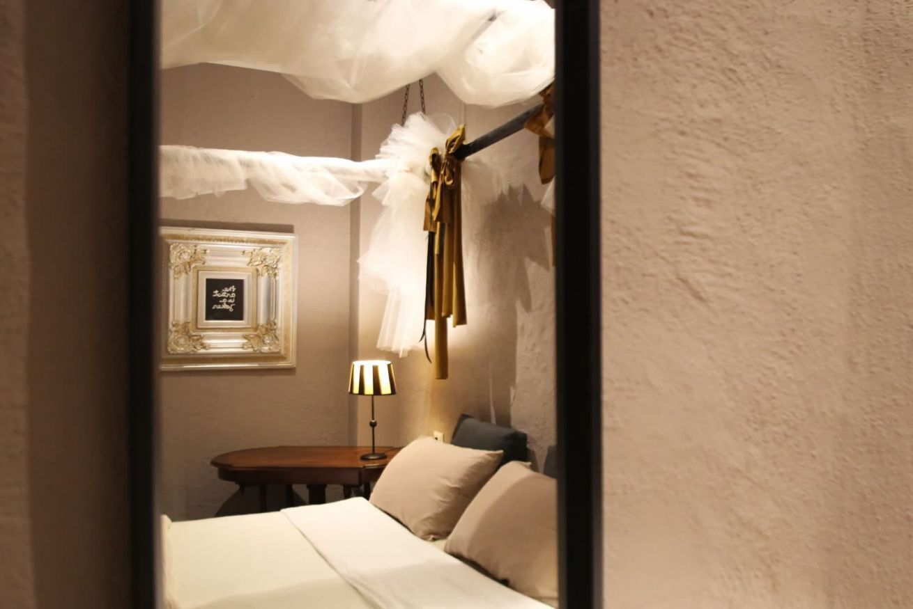 Una camera da letto con un letto, un comodino, una lampada e un quadro appeso al muro.