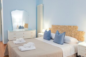 A bedroom with a bed, a nightstand, a dresser, a mirror, and a wall with a textured pattern. - Sottani di Puglia (Castellana Grotte)