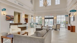 A spacious lobby with a reception desk, seating area, and a chandelier. - Lakefront 5BR Villa • Private Pool near Disney (Kissimmee)
