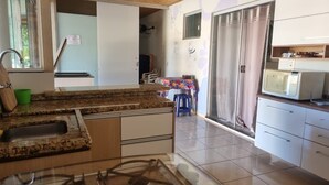 Cuina amb taulells de granit, fogó a gas, microones i nevera.