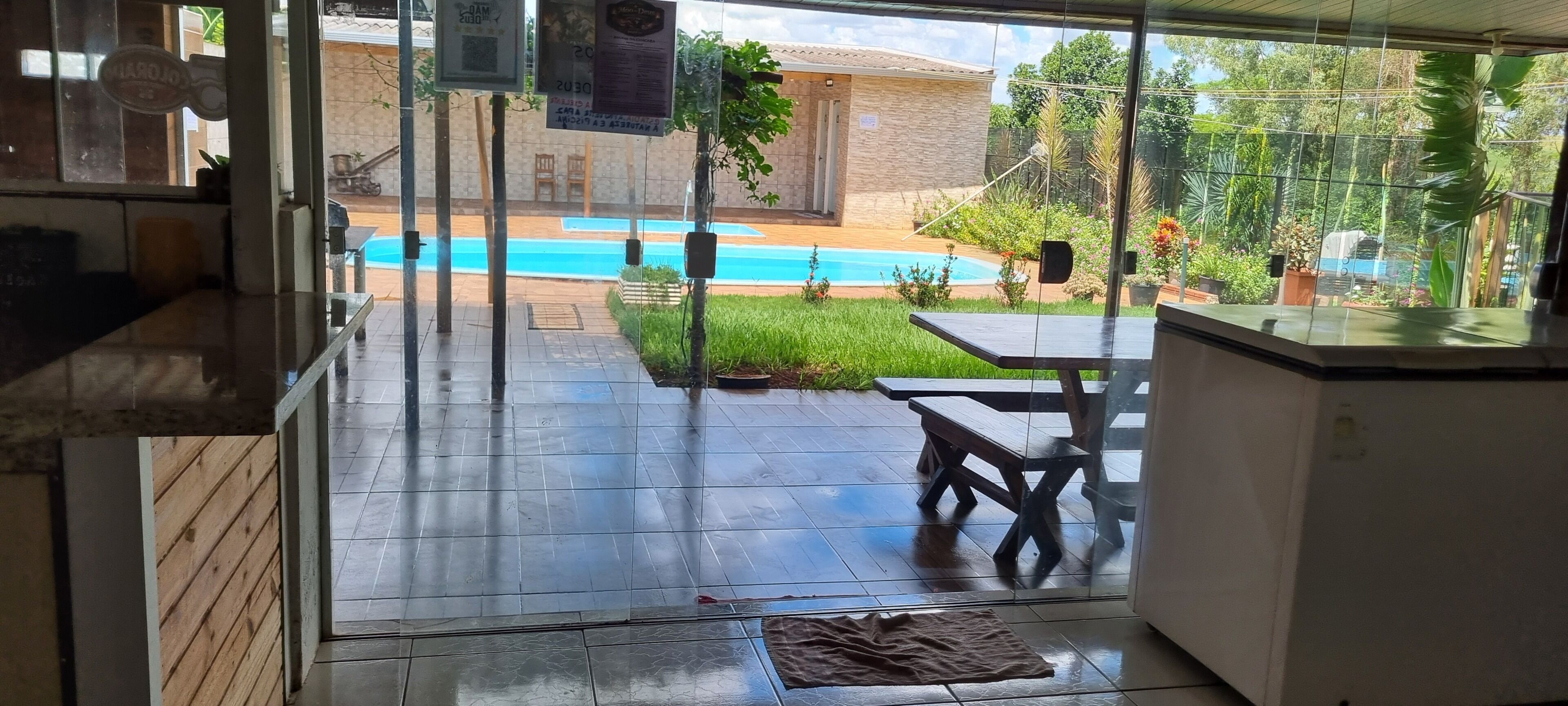 A patio area with a pool, a table, and chairs.
