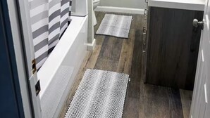 Een badkamer met douche, toilet en wastafel.
